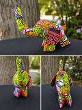 Handmade elephant plush crafted from colorful Ankara cotton fabric with a raised trunk, shown from front, side, and back views.