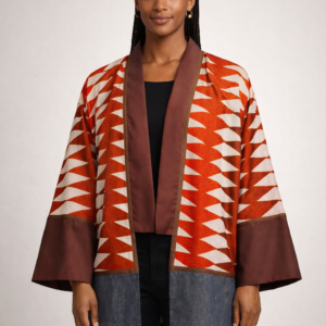 A front view of the Tasha geometric kimono featuring bold red, orange, and cream patterns with black trim, worn by a model Lise