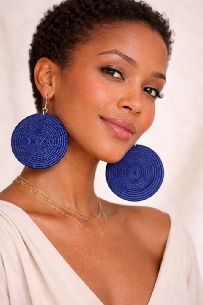woman wearing blue Rwandan woven statement earrings large disc African handmade earrings portrait.